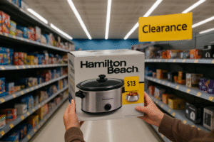 A shopper holds a Hamilton Beach slow cooker with a $13 clearance sticker in a Walmart aisle filled with discounted products, capturing a real example of Walmart clearance deals in 2025